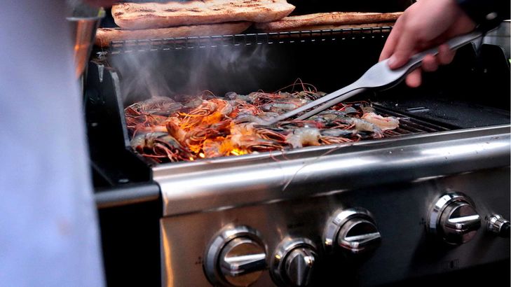 Auf dem Napoleon Grill werden Scampis und R&ouml;stbrot w&auml;hrend eines Firmen-Teamevents gegrillt