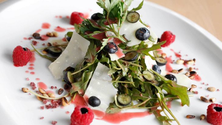 Rucolasalat mit Himbeer-Walnussdressing, jungem Pecorino und gerösteten Pinienkernen