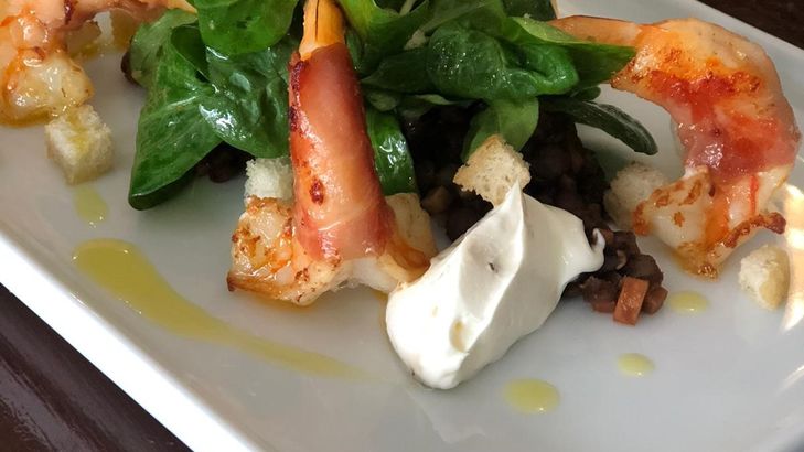 Lauwarme Tellerlinsen mit gebratenen Garnelen im Speckmantel, Feldsalat und Croutons